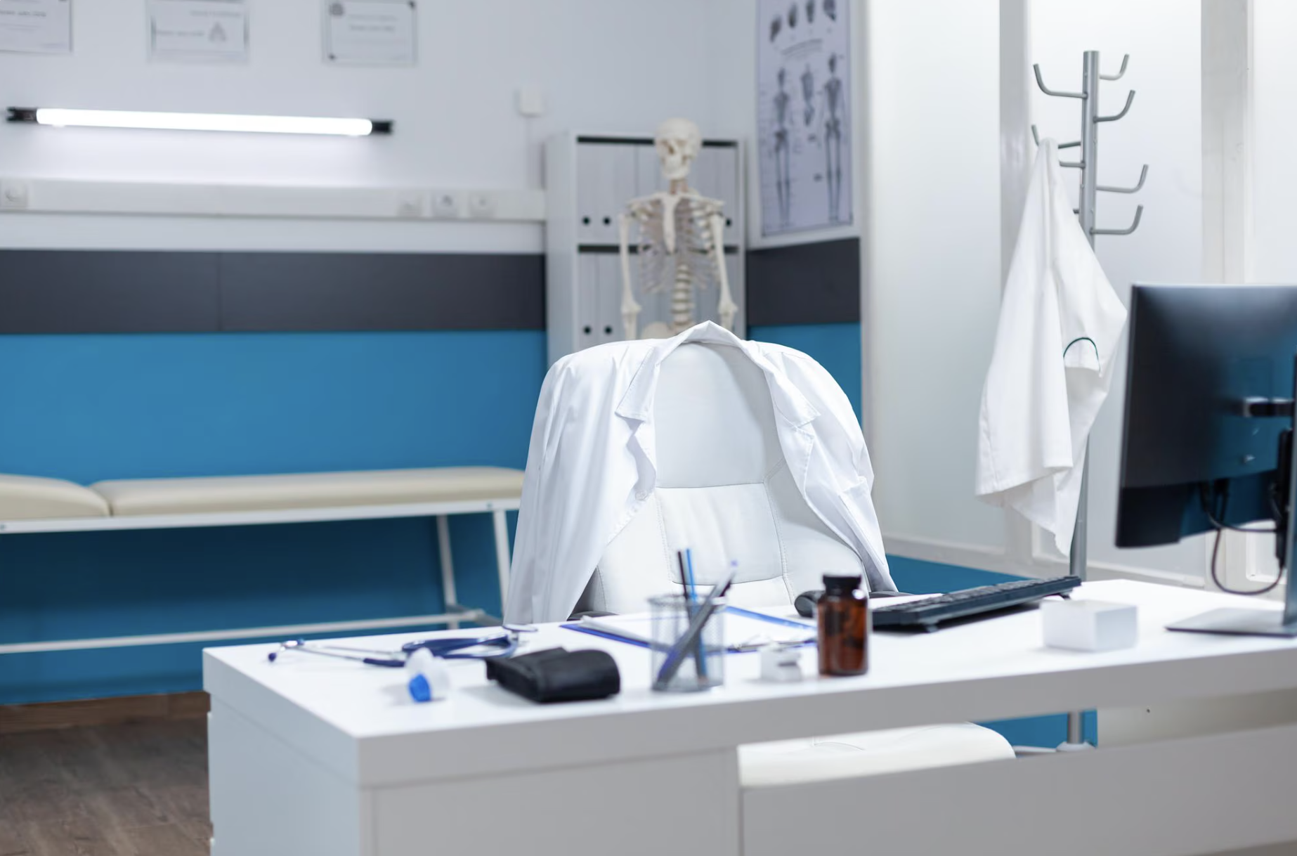 Consultório médico moderno com jaleco e equipamentos sobre a mesa